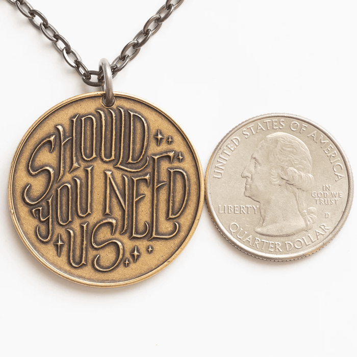 Labyrinth pendant shown with quarter for scale; pendant is slightly bigger