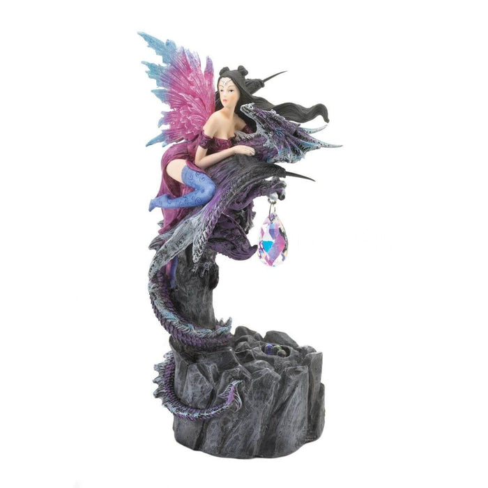Figurine showing a dragon with pink and blue wings in a purple dress and indigo stockings. She holds onto a purple dragon who has a crystal dangling from its claws.