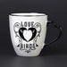 Closeup of Love Birds raven heart mug