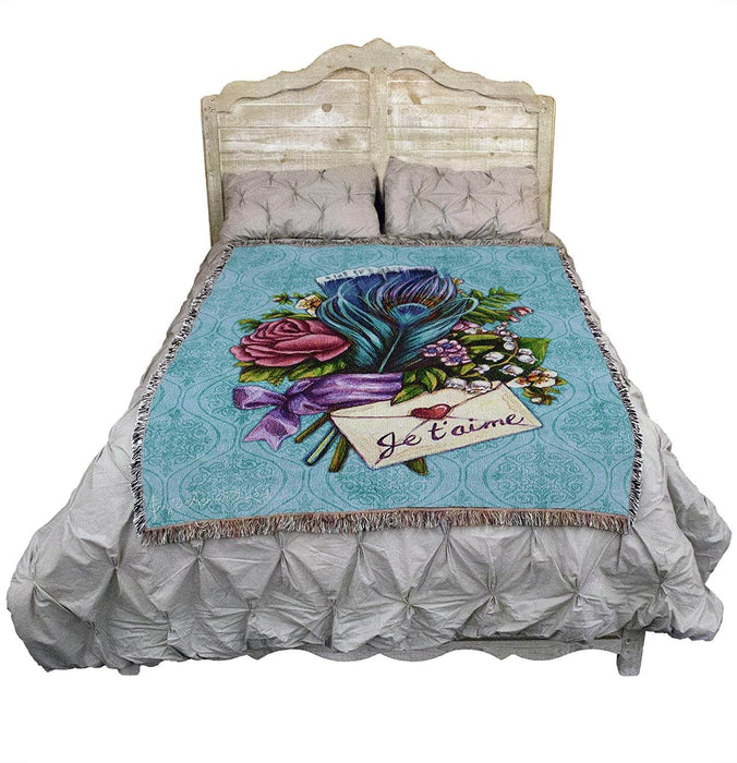"Je t'aime" letter and flower bouquet blanket displayed on a bed