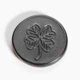 Black metal lucky coin showing clover