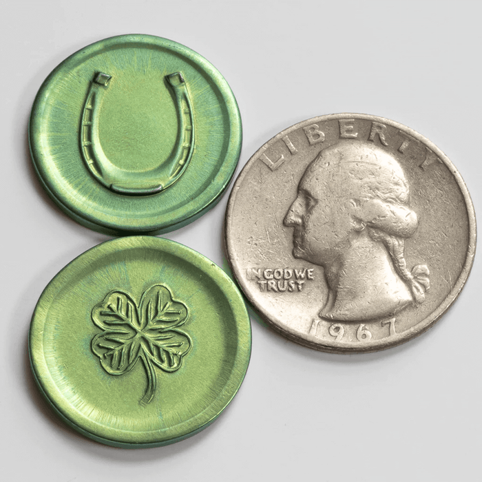 Green lucky coin with clover and horseshoe, shown next to US quarter for size comparison