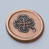 Copper lucky coin showing four leaf clover