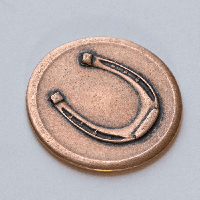 Copper lucky coin showing horseshoe