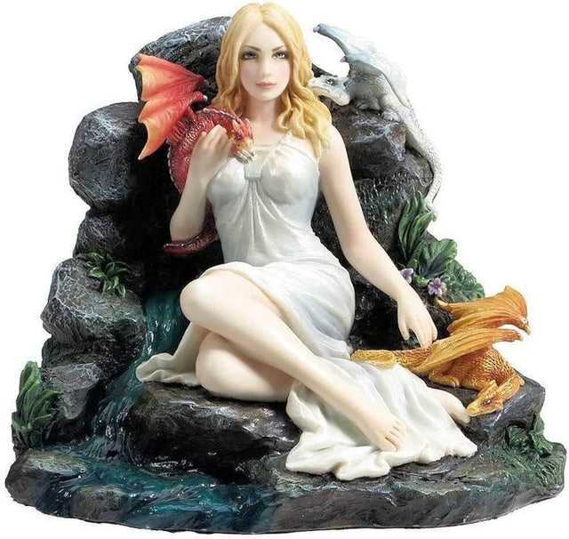 Blond woman in a white dress sits next to a small waterfall with three tiny dragons in red, white, and gold