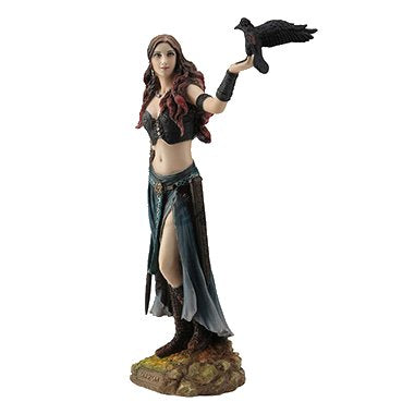 Morrigan the Celtic Goddess stands, clad in black and holding a sword in one hand and a raven on the other