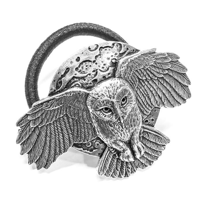Ponytail holder in pewter showing an owl with spread wings in front of a full moon, in 3d. Black ponytail holder