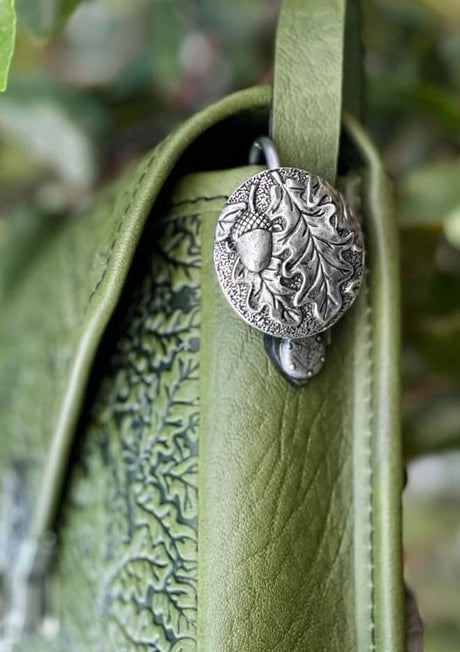 Oak leaf and acorn medallion purse hook shown on a green leather bag