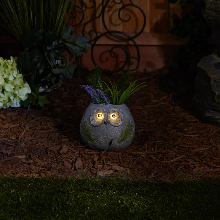 Owl flowerpot shown in the dark with solar-powered light up eyes