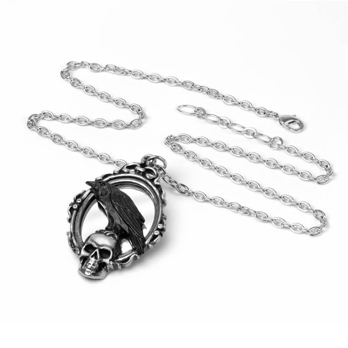 Necklace pendant featuring an ornate mirror with a skull and black raven perched atop the grinning skeleton. On a linked silver colored chain.