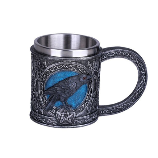A mug with gunmetal gray Celtic knot designs. A raven perches on a pentacle against a blue circle. There is a stainless steel insert to hold a drink