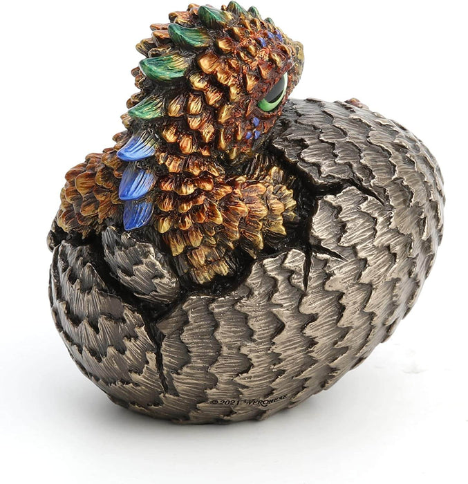 Baby dragon hatching from egg, done in shades of gold and red with blue and yellow accents and a green eye. Shown from the back to see green and blue spines