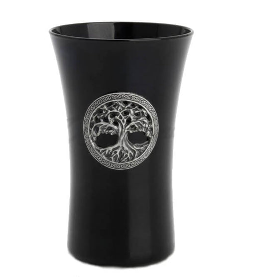 Black glass shotglass with a metal tree of life emblem on the front. The tree is surrounded by a Celtic knotwork border