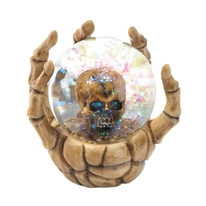Skeletal hand holding a snow globe with glitter and a skull inside