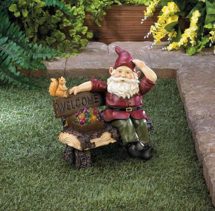 Gnome on bench with treasure chest and squirrel friend; bench says "Welcome". Displayed in a corner of a garden