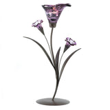 A tealight candle holder made to look like a deep purple lily flower with two smaller blossoms, on a metal stalk with leaves.