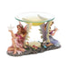 Twin fairy oil warmer featuring a pink and an indigo fairy with glittery wings, each holding a dove and holding up the glass oil warmer. The tealight candle sits on the forest floor between them.