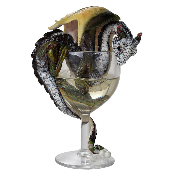 Gray, white and black dragon with green and yellow accents sitting in a wine glass of white wine