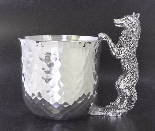 pewter cup with pewter wolf standing and paws on top of cup for handle.